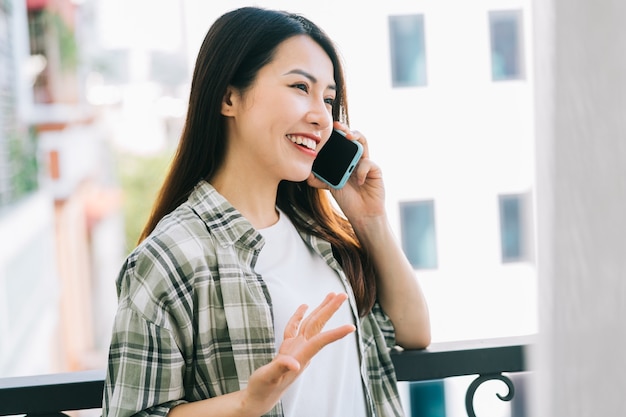 Portrait de jeune femme asiatique utilisant un smartphone à la maison