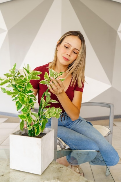 Portrait d'une jeune femme assise contre le mur