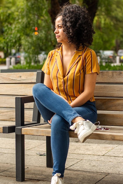 Portrait d'une jeune femme assise dans le parc