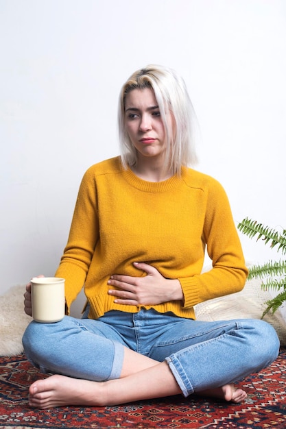 Photo portrait d'une jeune femme assise sur un fond blanc