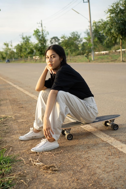 Portrait d'une jeune femme assise sur la route