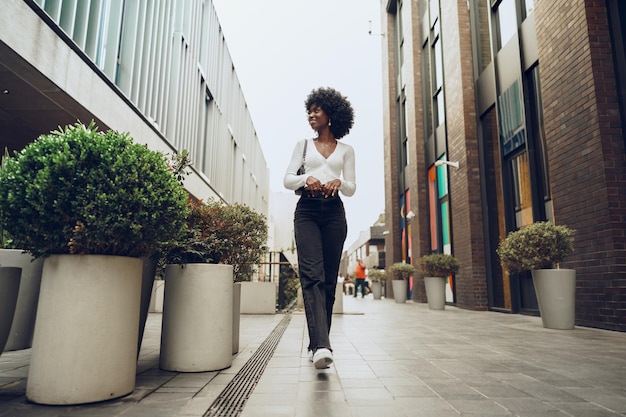 Photo portrait d'une jeune femme attirante marchant dehors dans la ville