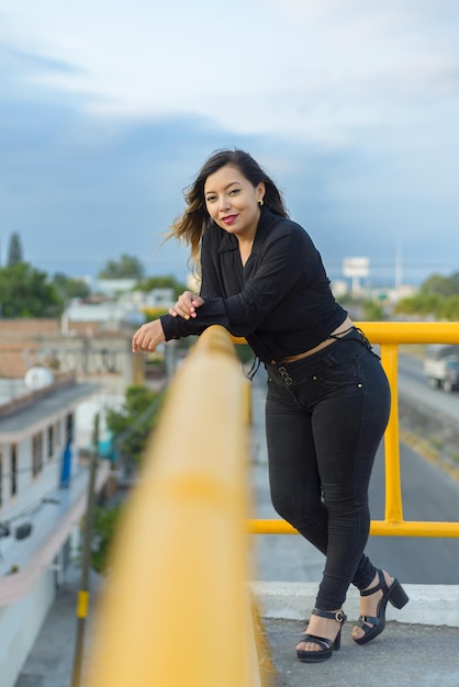 Portrait de jeune femme avec une attitude positive sur un pont piétonnier Coucher de soleil avec un ciel bleu