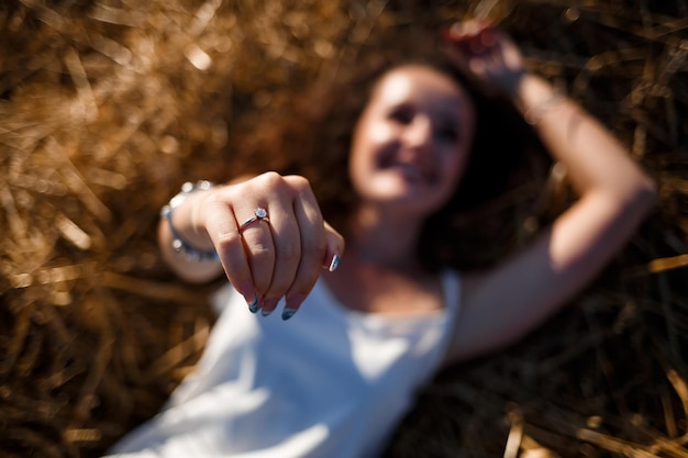 Portrait d'une jeune femme aux cheveux bouclés dans un champ de blé, où le blé est fauché tout en profitant de la nature. La nature. Rayons de soleil. Agriculture. Mise au point sélective