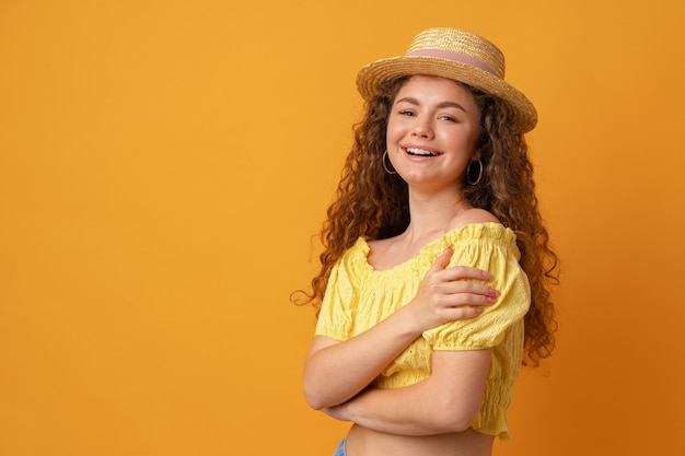 Portrait d'une jeune femme aux cheveux bouclés sur fond jaune