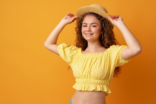 Portrait d'une jeune femme aux cheveux bouclés sur fond jaune