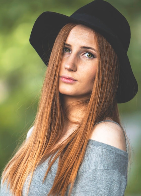 Portrait d'une jeune femme aux cheveux longs portant un chapeau