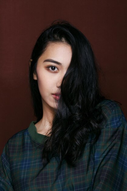 Photo portrait d'une jeune femme aux cheveux noirs ondulés