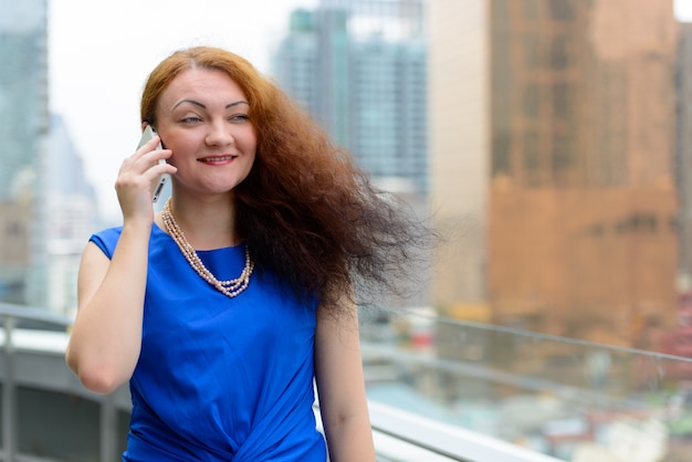 Portrait de jeune femme aux cheveux rouges dans la ville