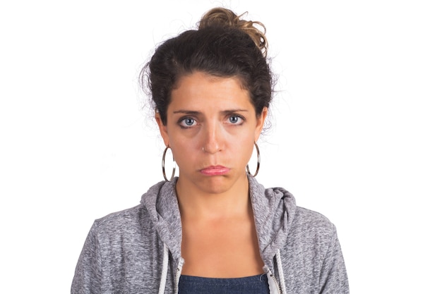 Photo portrait de jeune femme belle avec une expression triste mur blanc isolé.