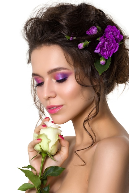 Portrait de jeune femme belle avec des fleurs violettes dans ses cheveux