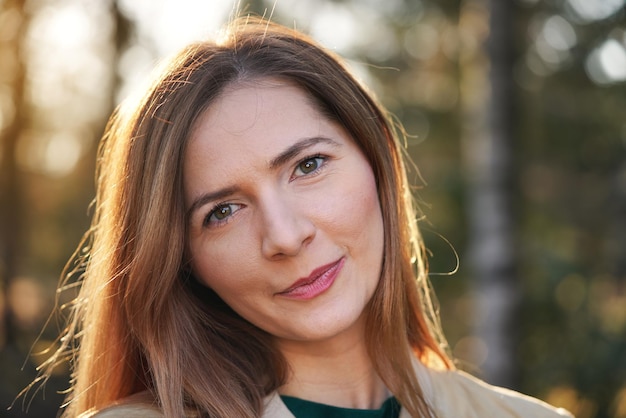 Portrait de jeune femme, belle forêt ensoleillée floue fond bokeh