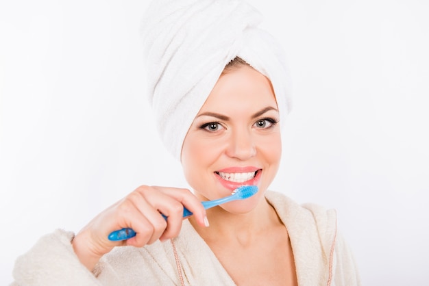 Portrait de jeune femme belle se brosser les dents avec une brosse à dents