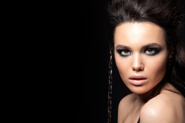 Portrait de jeune femme belle avec soirée maquillage modèle posant sur fond noir