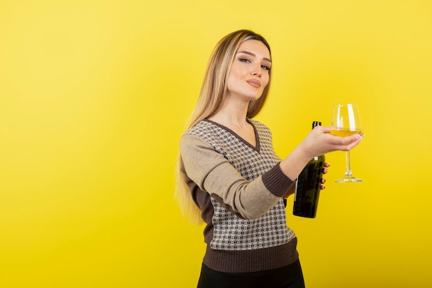 Portrait de jeune femme belle avec verre de vin blanc posant.