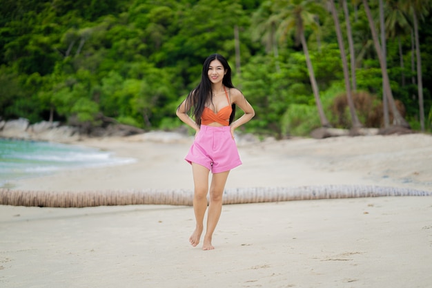 Photo portrait de jeune femme en bikini orange sur la plage tropicale