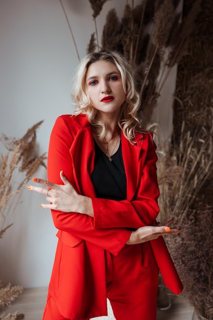 portrait d'une jeune femme blonde élégante dans un costume rouge