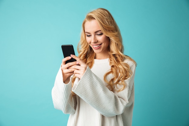 Portrait d'une jeune femme blonde souriante en pull