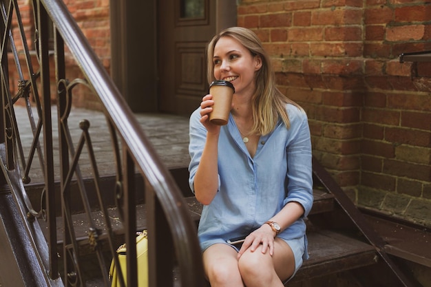 Portrait d'une jeune femme boit du café la rue de la ville