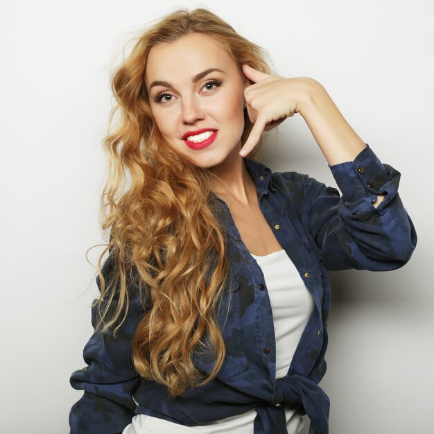 Portrait d'une jeune femme bouclée assez souriante. Blond heureux.