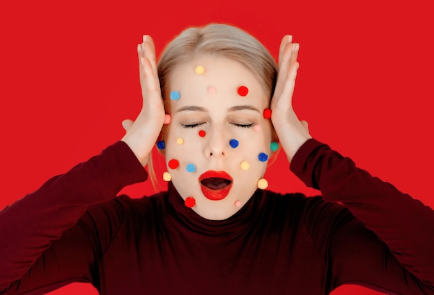Portrait de jeune femme avec des boules colorées sur le visage