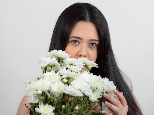 Portrait d'une jeune femme avec un bouquet de fleurs blanches