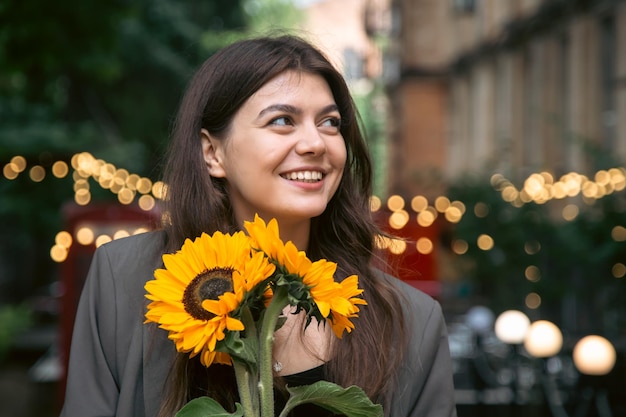 Portrait d'une jeune femme avec un bouquet de tournesols