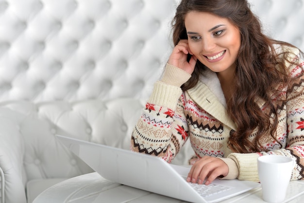 Portrait d'une jeune femme brune à l'aide d'un ordinateur portable