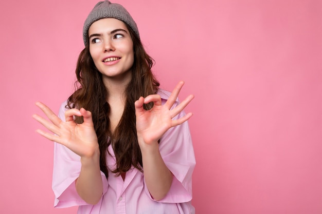 Portrait de jeune femme brune aux cheveux ondulés attrayante heureuse positive avec des émotions sincères portant