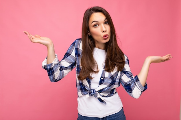 Portrait de jeune femme brune belle réfléchie avec des émotions sincères portant une chemise à carreaux élégante