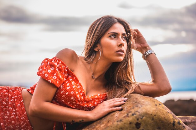 Portrait d'une jeune femme brune dans une robe rouge