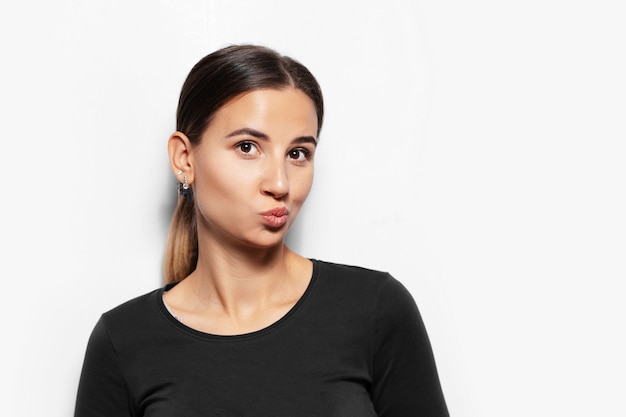 Portrait de jeune femme brune envoyer un baiser aérien.