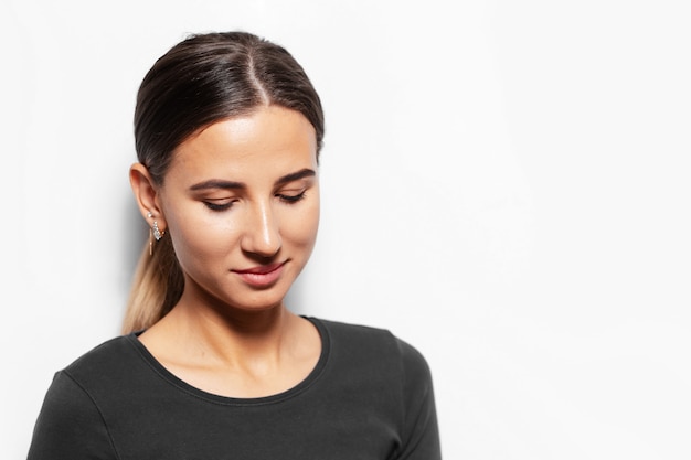 Portrait de jeune femme brune regardant vers le bas.