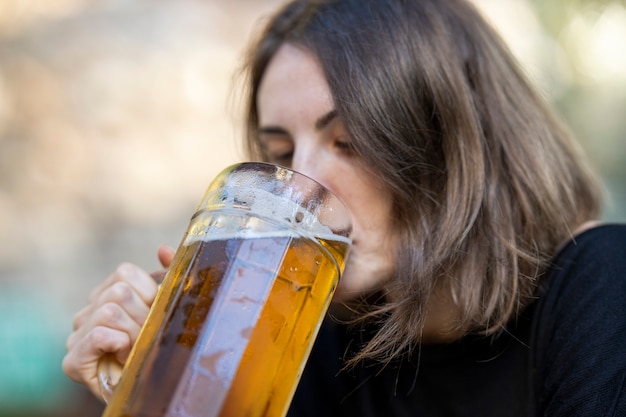 Portrait de jeune femme buvant de la bière au bar