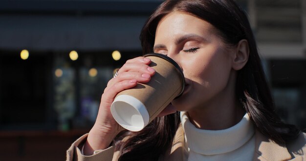 Portrait de jeune femme buvant du café à emporter Femme relaxante en gros plan avec du café à emporter