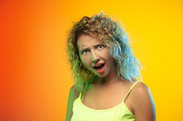 Portrait de jeune femme caucasienne sur fond de studio dégradé en néon