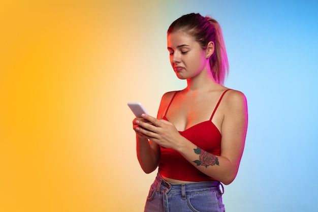 Portrait de jeune femme caucasienne sur fond de studio dégradé en néon