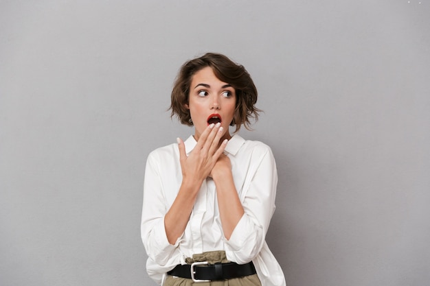 Portrait d'une jeune femme choquée vêtue d'une chemise blanche