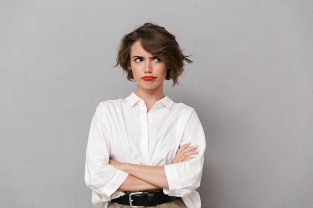 Portrait d'une jeune femme en colère vêtue d'une chemise blanche