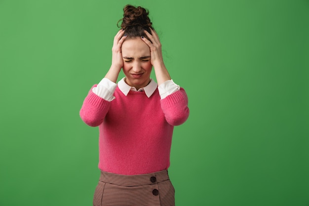 Portrait d'une jeune femme confuse debout isolé sur vert