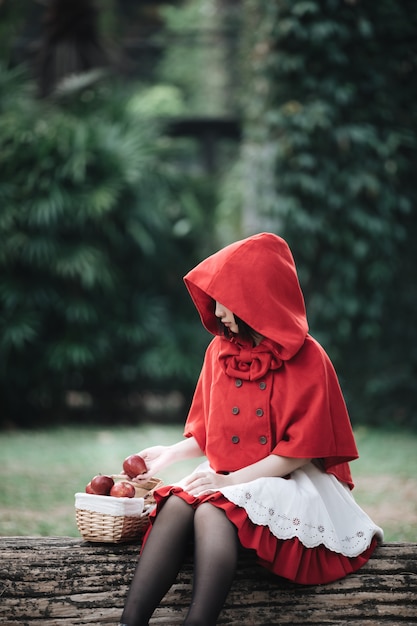 Portrait de jeune femme en costume de petit chaperon rouge au parc de l&#39;arbre vert