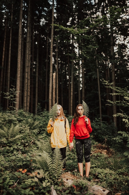 Photo portrait de jeune femme couple main dans la main dans la forêt.