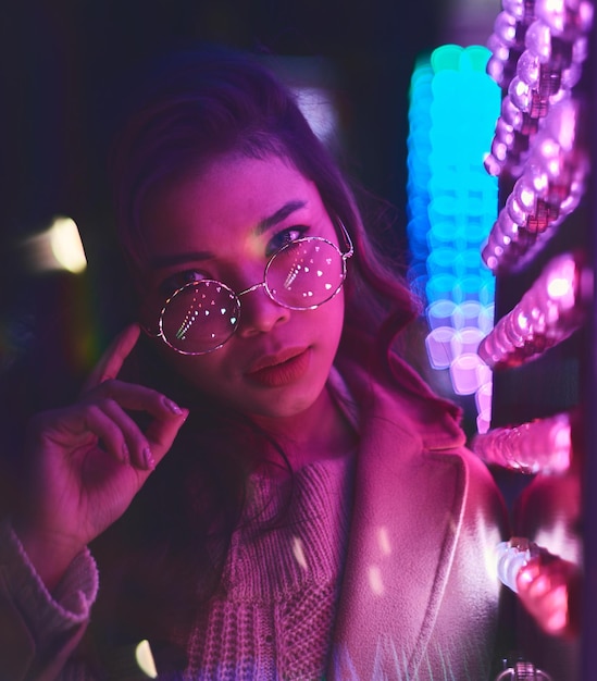 Portrait d'une jeune femme dans une boîte de nuit vu à travers le verre