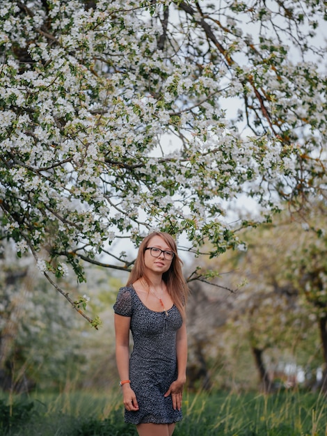 Portrait d'une jeune femme dans un jardin de pommes vertes au printemps