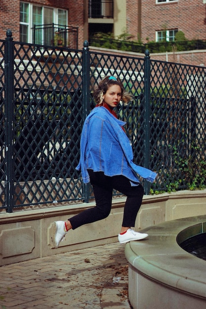 Portrait d'une jeune femme debout sur la balustrade contre la clôture