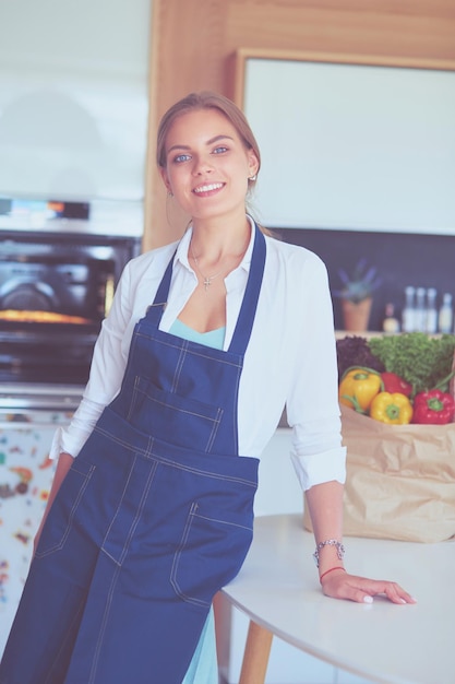 Portrait de jeune femme debout avec les bras croisés sur fond de cuisine