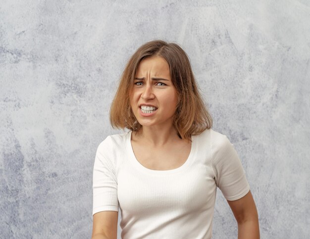 Portrait d'une jeune femme debout contre le mur