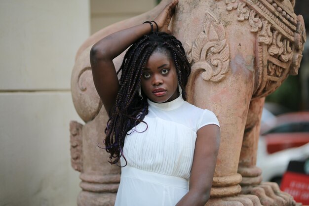 Portrait d'une jeune femme debout contre le mur