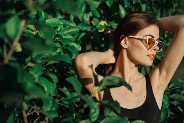 Photo portrait d'une jeune femme debout contre des plantes