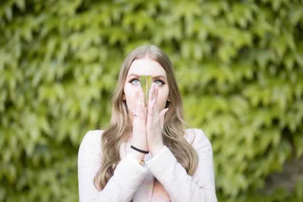 Photo portrait d'une jeune femme debout contre des plantes